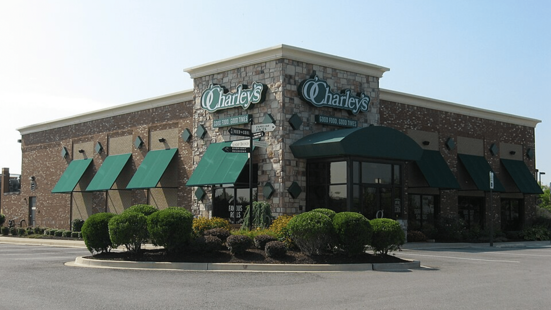 Exterior of a brick O'Charley's restaurant with green awnings.