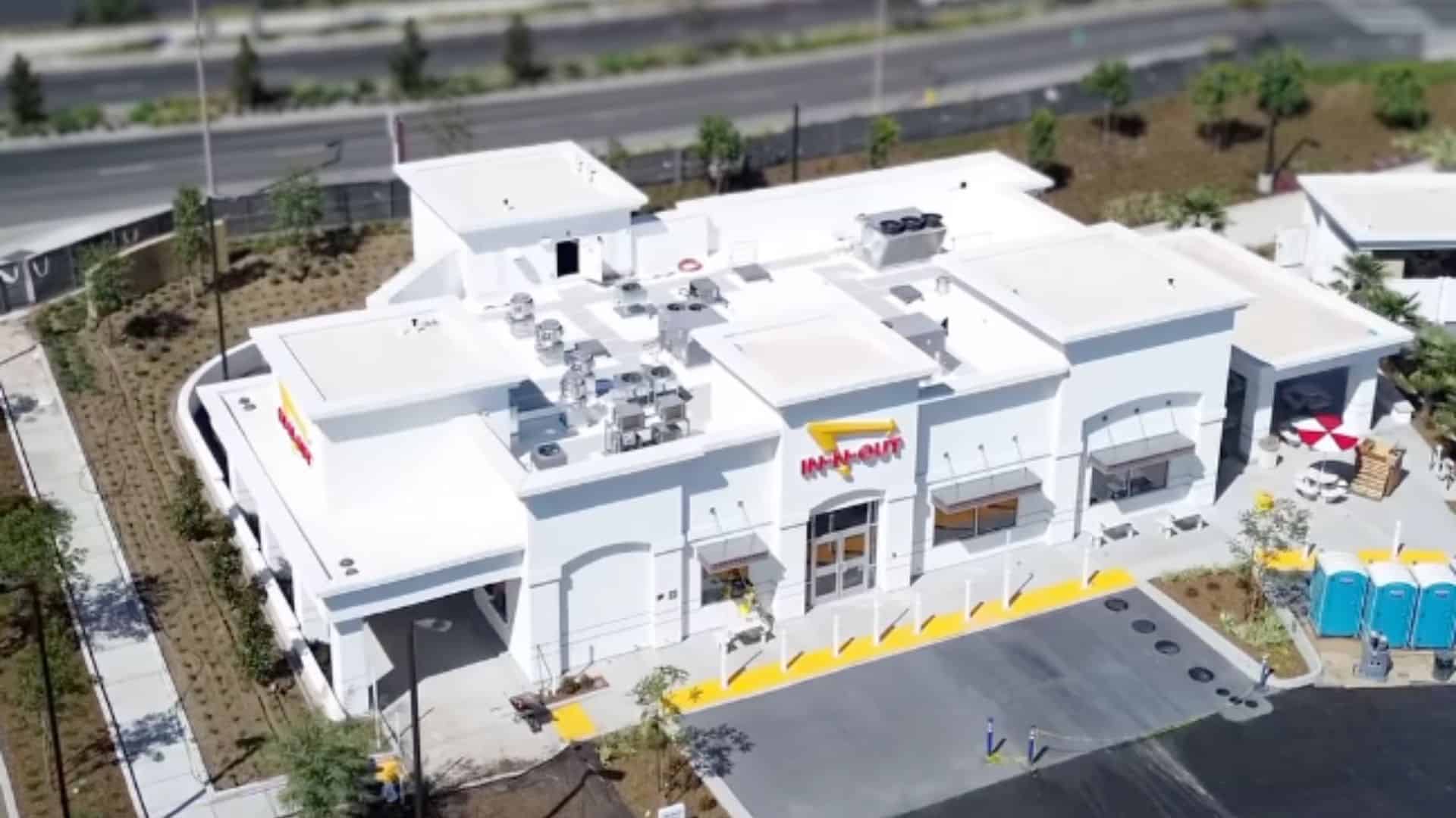 Aerial view of the new In-N-Out restaurant in Irvine, California, showing its white exterior and outdoor seating area.
