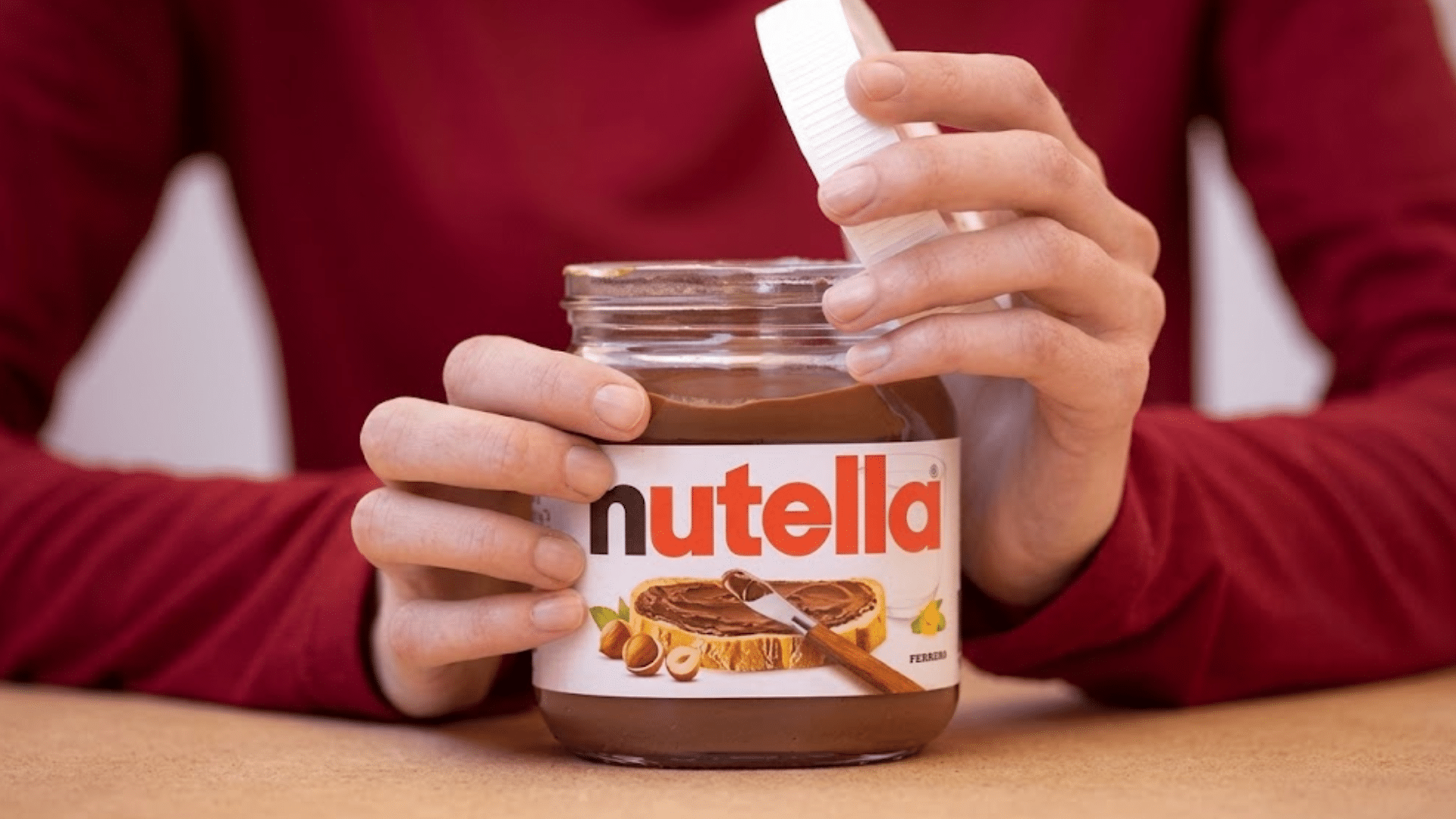 A woman opening a Nutella jar.