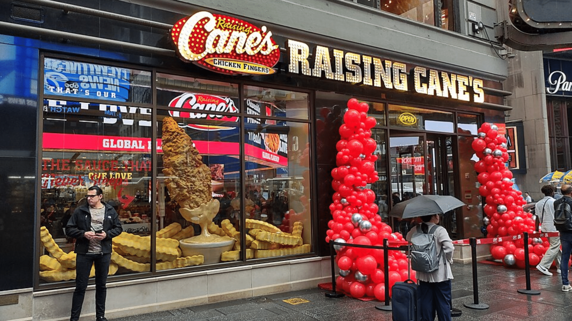 Raising Cane's in Times Square with window displays and balloon arches.