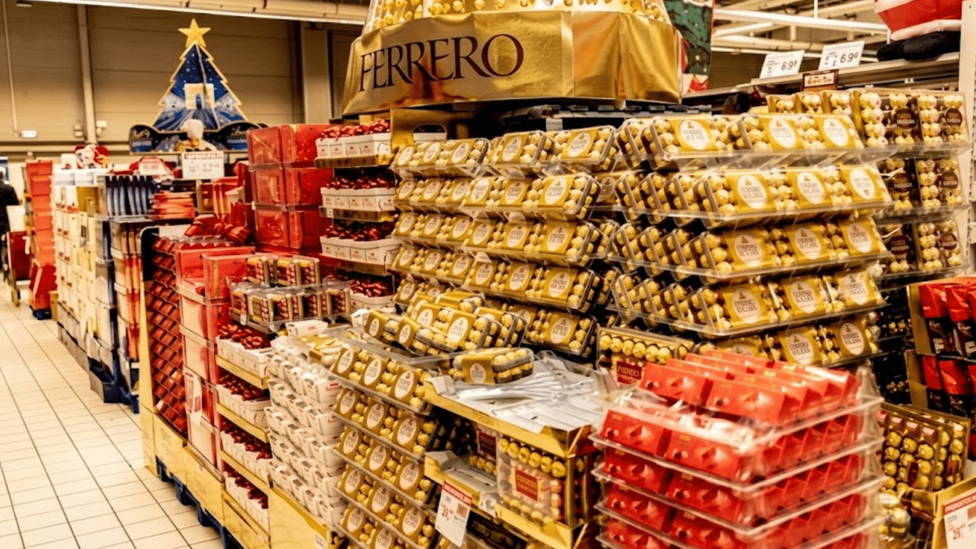 Sweets on the shelves of a supermarket. Golden pallets displaying Ferrero Collection gift boxes with Rocher chocolates.